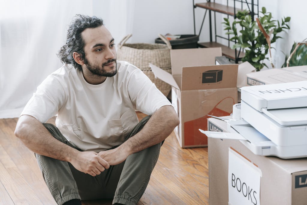 Man Sitting On Floor Beside Boxes